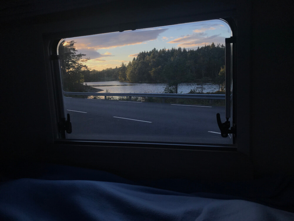 Aussicht aus dem Fenster des Wohnmobils auf einen kleinen See beim Sonnenuntergang in der Nähe des Preikestolen